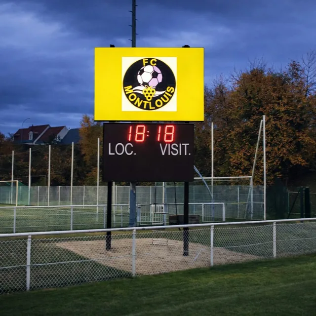 Tableau de score et panneau LED au bord d’un terrain de sport.